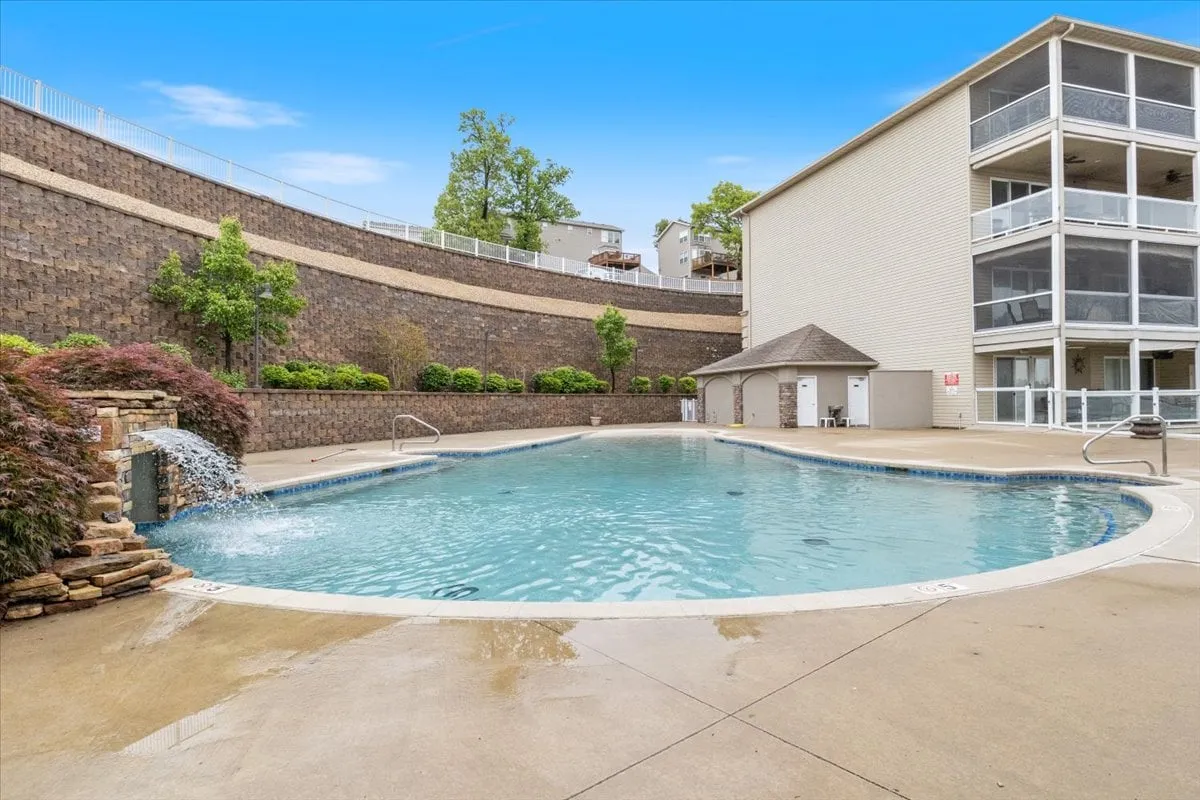 A tranquil swimming pool with a waterfall feature and surrounding landscaping, adjacent to the building structure. The area evokes relaxation and resort-style amenities, suggesting a place to unwind after a day of boating. The overall mood is leisure-oriented and calming.