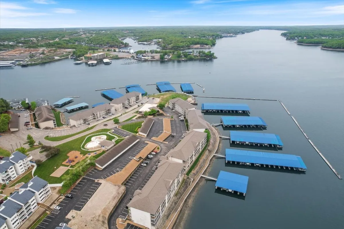 This image features a marina with boat docks, surrounded by lush greenery and waterfront residences. The tranquil water, visible docks, and boats evoke the lakefront lifestyle, while the residential backdrop hints at the convenience of dockside living. The scene is picturesque and recreational, with a clear focus on boating activities and the connection to the water.